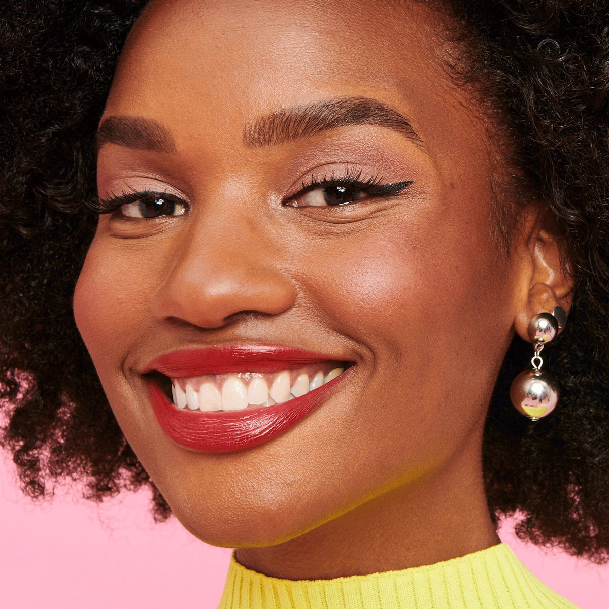 Smiling model wearing Benefit Roller Liner black waterproof eyeliner